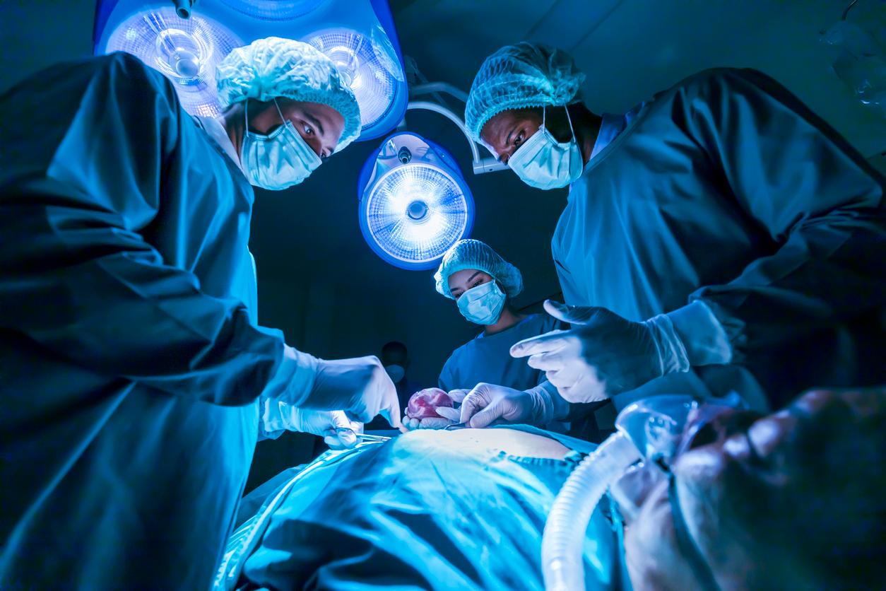 A team of medical surgeons perform surgery on a patient.